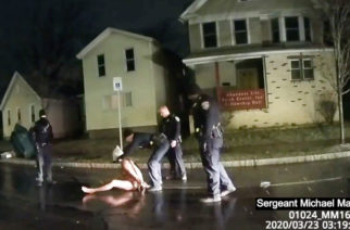 In this image taken from police body camera video provided by Roth and Roth LLP, a Rochester police officer puts a hood over the head of Daniel Prude, on March 23, 2020, in Rochester, N.Y. Video of Prude, a Black man who had run naked through the streets of the western New York city, died of asphyxiation after a group of police officers put a hood over his head, then pressed his face into the pavement for two minutes, according to video and records released Wednesday, Sept. 2, 2020, by his family. Prude died March 30 after he was taken off life support, seven days after the encounter with police in Rochester. (Rochester Police via Roth and Roth LLP via AP)