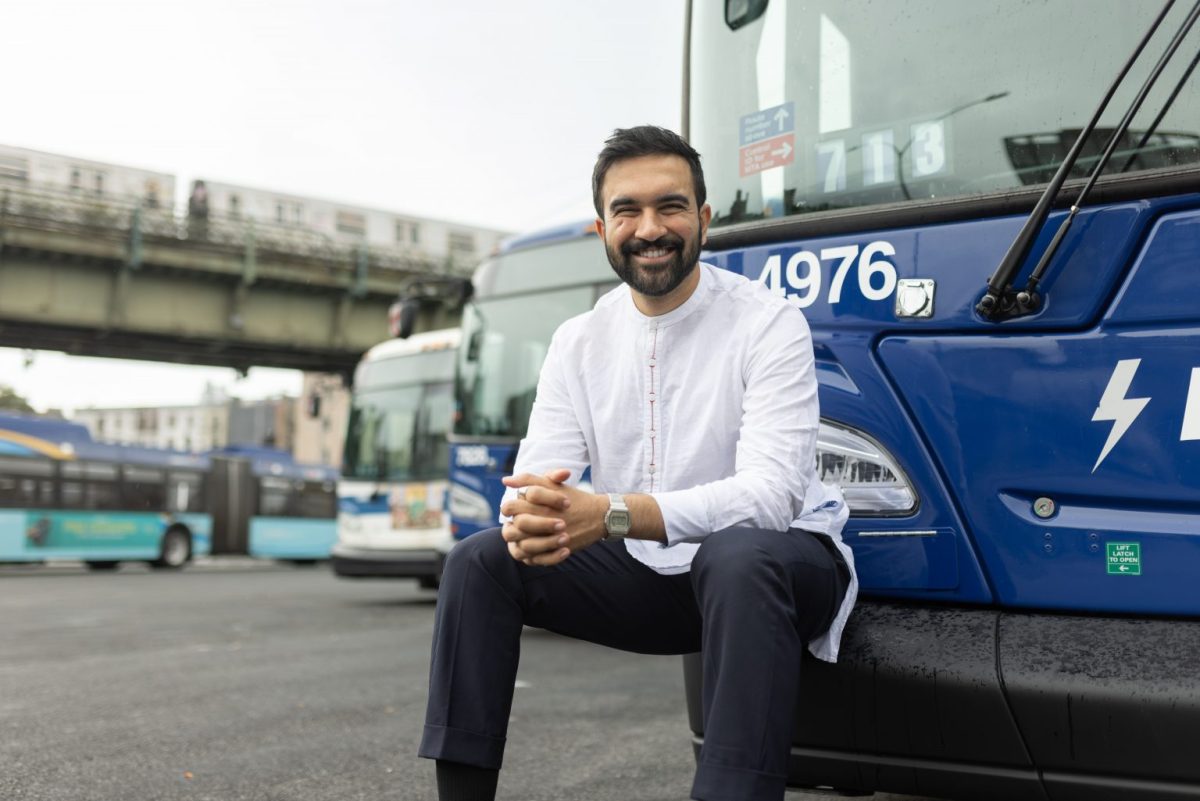 Photo: Zohran Mamdani sitting against a city bus - Zohranfornyc.com
